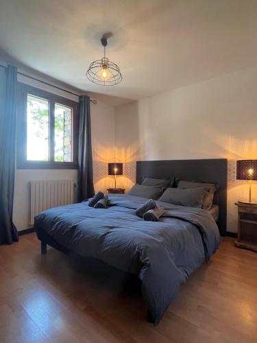 a large bed in a bedroom with two lamps at Appartement rez de jardin, 2 chambres/ 4 personnes, garage. in Briançon