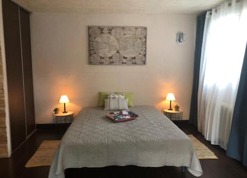 a bedroom with a bed and two lamps on two tables at Studio Bijou Plage Antibes Juan-les-Pins in Antibes