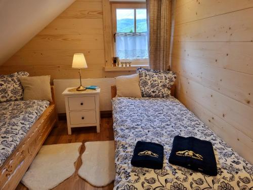 a bedroom with two beds in a log cabin at Złoty Dom Brenna in Brenna