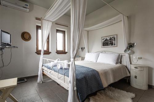 1 dormitorio con 1 cama con dosel en ILOI’s Villa in peaceful Village w. Private Beach, en Koropi