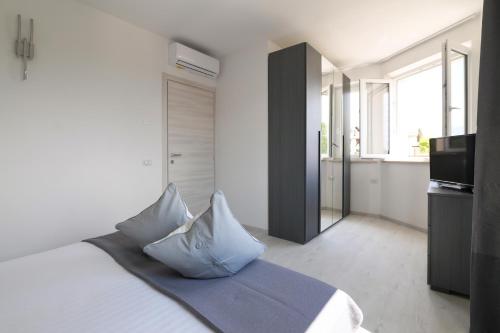a bedroom with a bed with pillows and a kitchen at Borgo degli Ulivi Residence di Olympic Garda Lake in Toscolano Maderno
