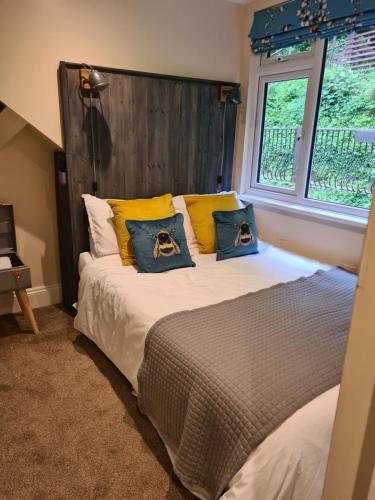 a bedroom with a bed with yellow and blue pillows at The Eaves in Lynton, Exmoor, Devon in Lynton