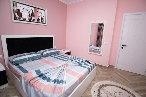 a bedroom with a large bed with pink walls at Elton Home Tushemisht in Pogradec