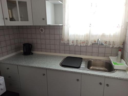 a kitchen counter with a sink and a window at Lovely beachfront studio in Malaki