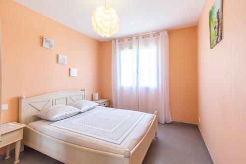 Schlafzimmer mit einem Bett und einem Fenster in der Unterkunft Maison chaleureuse avec jardin 1500m2 in Villefranche-de-Rouergue