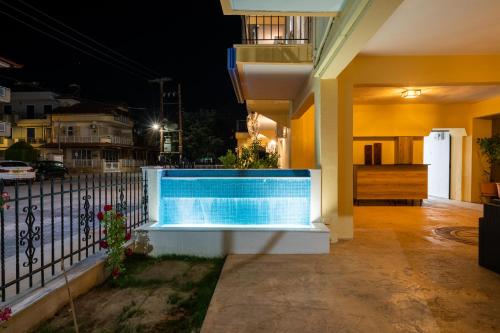 a swimming pool in front of a house at night at Apartments Kalina in Leptokaria