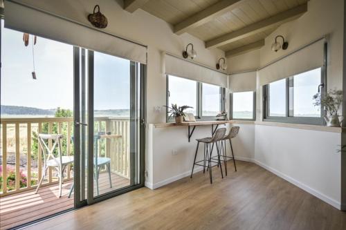 a room with a balcony with a table and chairs at צימר חלון לרקפות zimer Window for primroses עם ג'קוזי לנוף in Tal Shaẖar