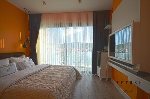 a bedroom with a bed and a large window at Ferush Boutique Hotel in Urla