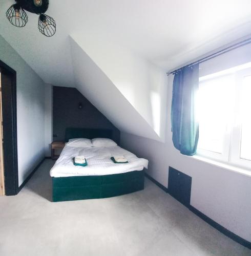 a small bedroom with a bed in a attic at Pogodny Domek in Zarzecze