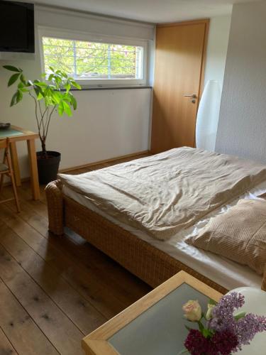 1 dormitorio con 1 cama con mesa y ventana en Ferienwohnung Wald-Stadt-Blick, en Erfurt