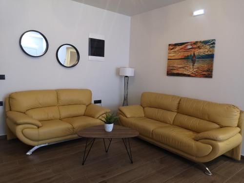 a living room with two couches and a table at SUNNY HOLIDAYS APARTMENT in Kremasti