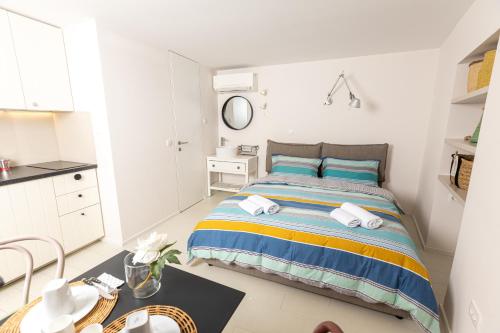 a bedroom with a bed with blue and yellow stripes at Piran Holiday Apartments in the city center in Piran