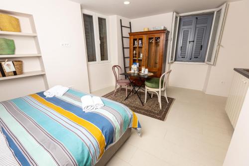 a bedroom with a bed and a table and chairs at Piran Holiday Apartments in the city center in Piran