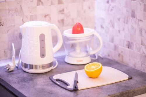 a food processor and an orange on a counter at Foča Apartmani "Story Lux" in Foča