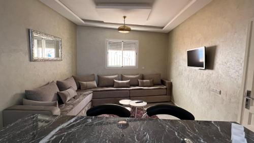 un soggiorno con divano e TV di Tiwaline Tarsime App A a Sidi Ifni