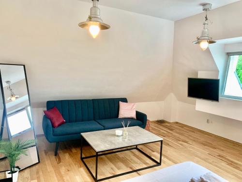 un soggiorno con divano blu e tavolo di Minimalist Apartment a Sofia