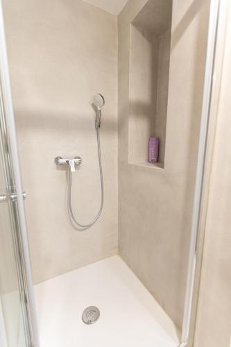 a shower with a shower head in a bathroom at Piran Holiday Apartments in the city center in Piran