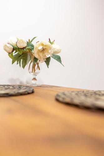 a vase filled with white flowers sitting on a table at Piran Holiday Apartments in the city center in Piran