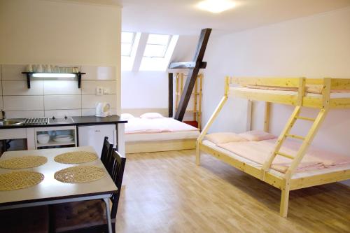 パソフラーフキにあるUbytování U Vojtěškyの二段ベッド2台とテーブルが備わる客室です。