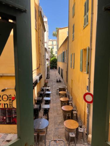 an alley with tables and chairs in an alley between buildings at Appartement T2 vieille ville d’Ajaccio in Ajaccio