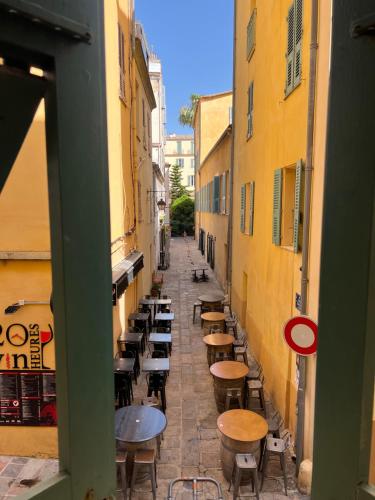 alejka ze stołami i krzesłami w alejce między budynkami w obiekcie Appartement T2 vieille ville d’Ajaccio w Ajaccio