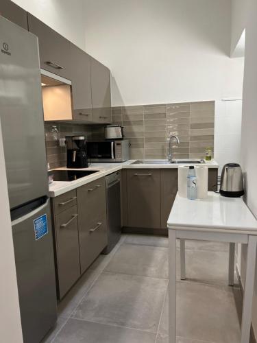 une cuisine avec des appareils en acier inoxydable et une table blanche dans l'établissement Appartement T2 vieille ville d’Ajaccio, à Ajaccio