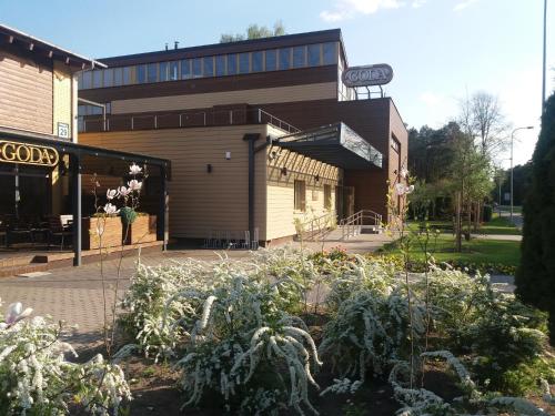a building with a garden in front of it at Airida Forest Apartment in Druskininkai