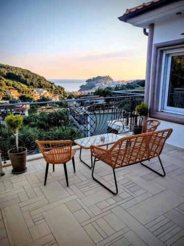 a patio with chairs and a table on a balcony at Natura Luxury Suites Parga in Parga