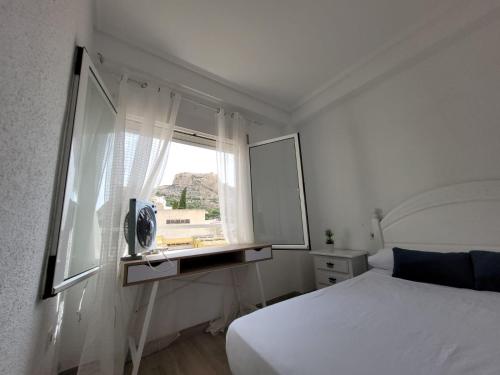 een slaapkamer met een wit bed en een raam bij Corazón de Alicante con vistas al mar y al castillo in Alicante