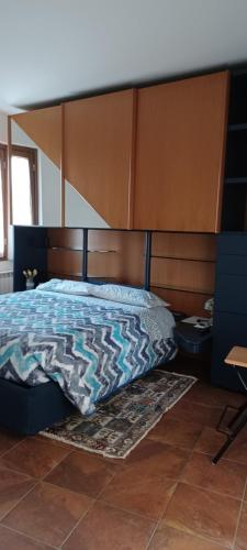1 dormitorio con 1 cama con cabecero de madera grande en Luminoso tra i rami del Lago di Como, Sormano, en Sormano