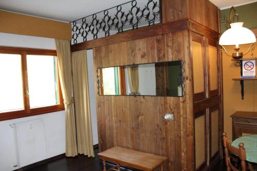 um quarto com uma parede de madeira com um espelho em casa Luca Prato Verde 1 em Pescasseroli