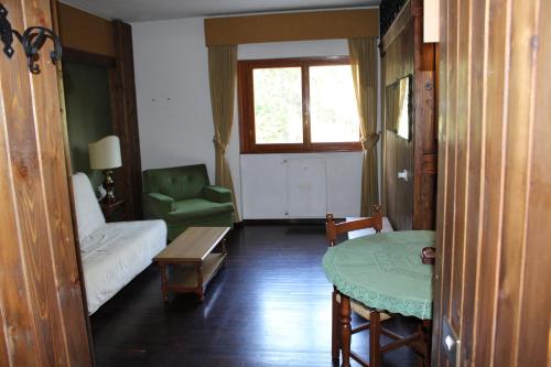 a living room with a table and a green chair at casa Luca Prato Verde 1 in Pescasseroli