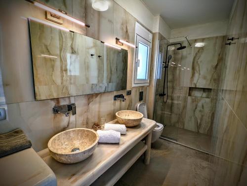 a bathroom with two sinks and a shower at Natura Luxury Suites Parga in Parga