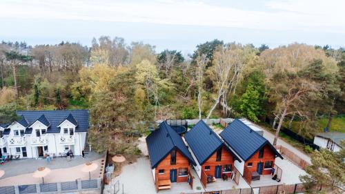an overhead view of a large house with black roofs at Domki na wydmie in Dziwnówek