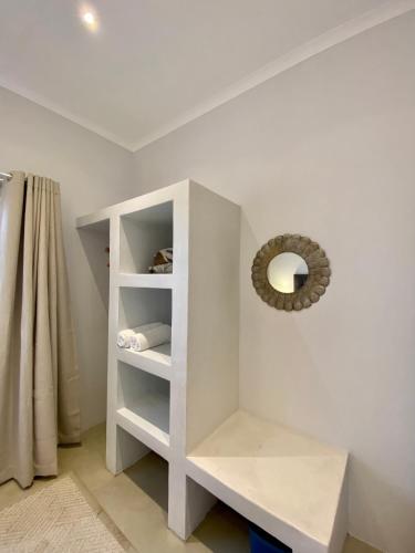 a white book shelf in a room with a mirror at Rosetta Fields Country Lodge in Rosetta