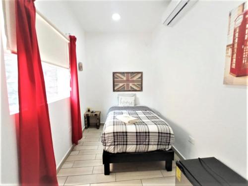 a bedroom with a bed and a red curtain at La Maja Suites in Villahermosa