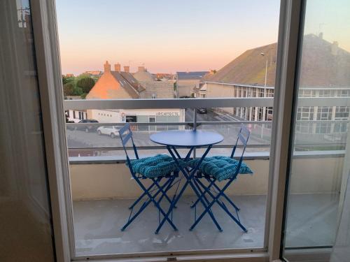 a table and two chairs on a balcony with a view at Le cosy in Courseulles-sur-Mer
