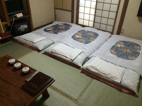 Cama grande en habitación con mesa en Nihonkan en Kioto