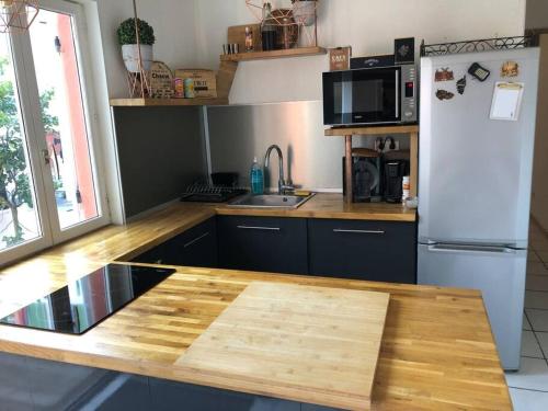 W kuchni znajduje się drewniany blat i lodówka. w obiekcie Appartement proche toutes commodités w mieście Tulon