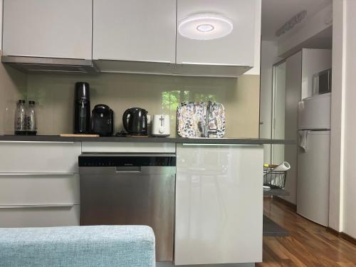 a kitchen with white cabinets and stainless steel appliances at Ferienwohnung Mazur in Murnau am Staffelsee