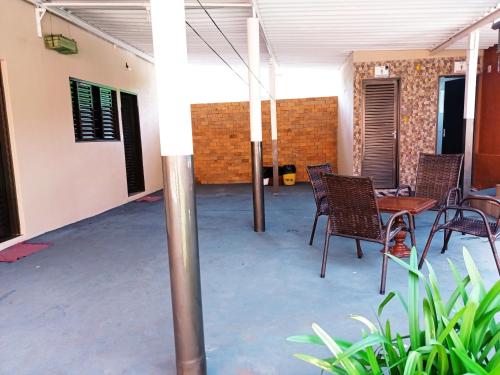a patio with chairs and a table in a building at Pousada Menina Moça in Olímpia