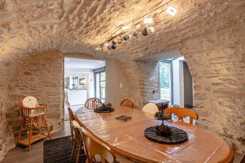 une salle à manger avec une grande table et des chaises en bois dans l'établissement Le clos des vignes, à Villefranche-de-Rouergue