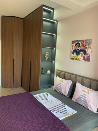 - une chambre avec un lit violet et une armoire dans l'établissement Lovely 1-bedroom Condo in Tirana WiFi-Netflix-AC, à Tirana