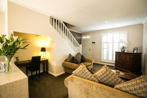 a living room with a couch and a staircase at Gallery Apartments in Warrnambool
