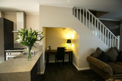 a kitchen with a staircase and a living room at Gallery Apartments in Warrnambool