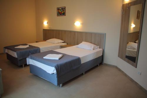 ein Hotelzimmer mit 2 Betten und einem Spiegel in der Unterkunft Александра Палас in Kranewo