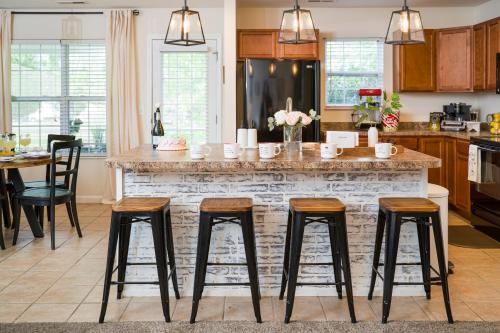 a kitchen with a large island with bar stools at Luxe Quiet Townhouse w/Parking/Pool/By Dollywood in Pigeon Forge