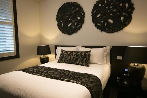 a bedroom with a bed with black and white pillows at Gallery Apartments in Warrnambool