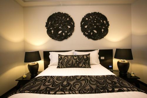 a bedroom with a bed with two black mirrors on the wall at Gallery Apartments in Warrnambool