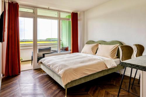 a bedroom with a bed and a large window at Apartment im Olympia Hotel Schilksee in Kiel